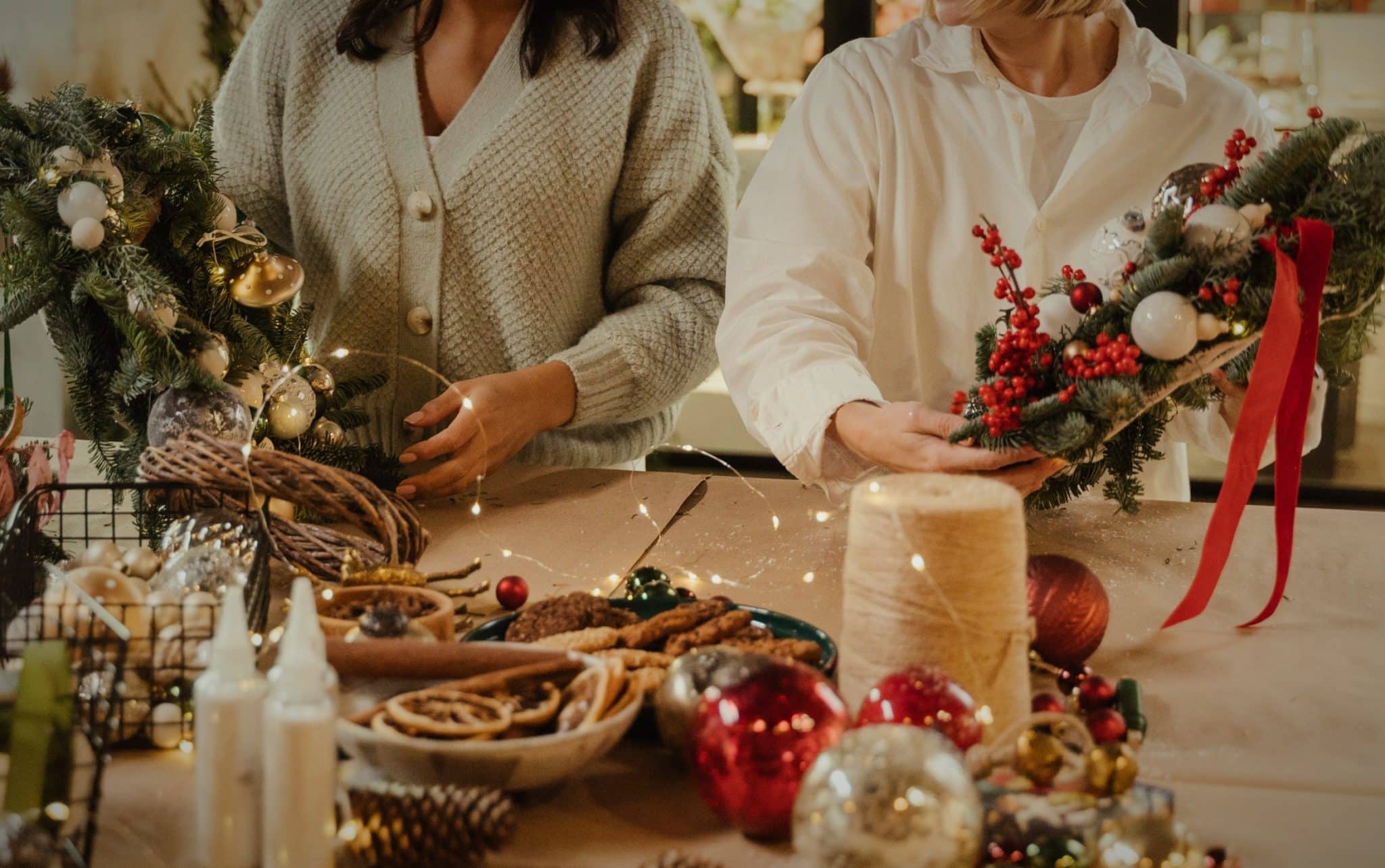 Two people participating in a Christmas wreath workshop