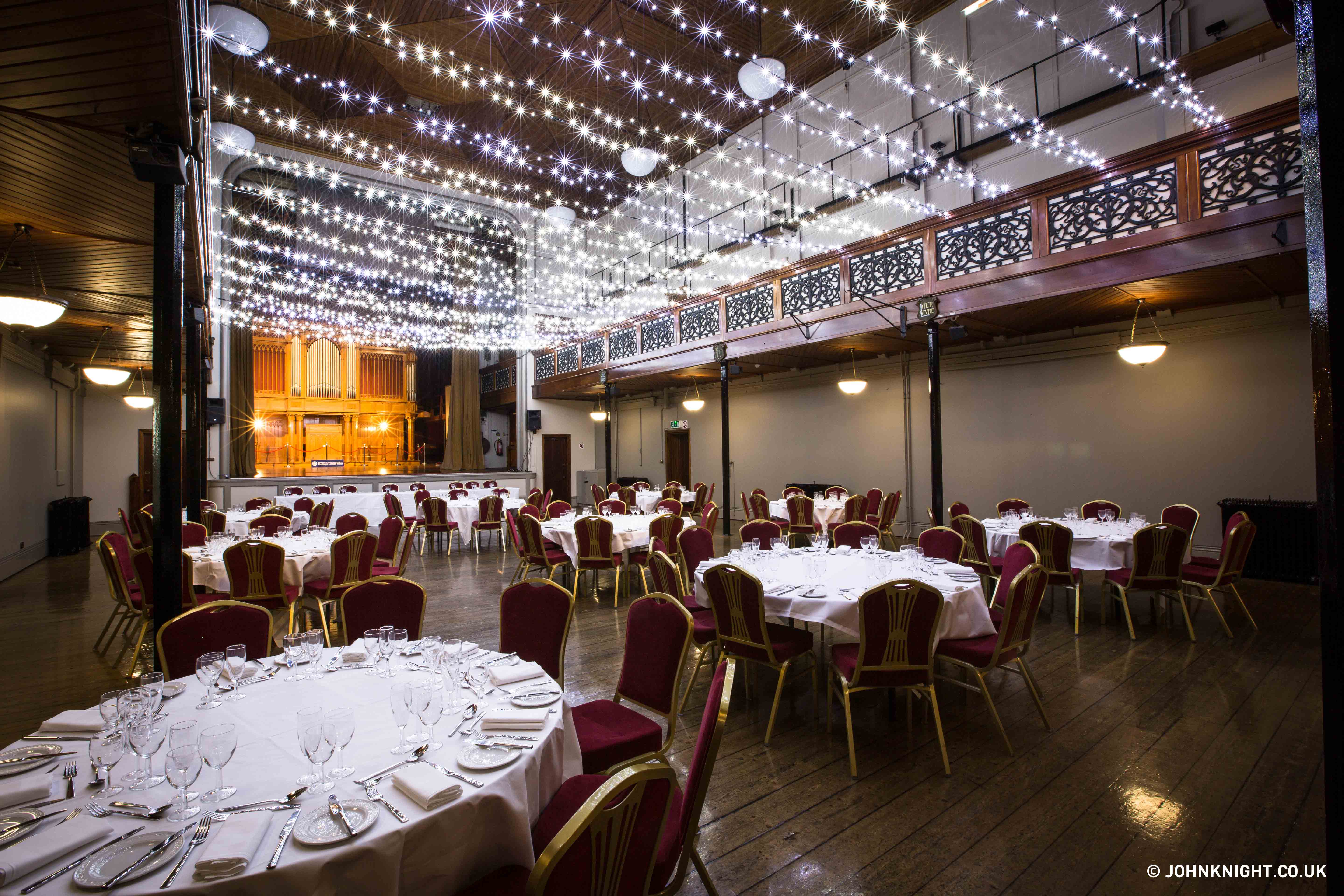 Prom venue decorated with red chairs and lots of small lights