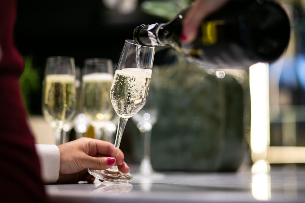 Person pouring champagne into a glass