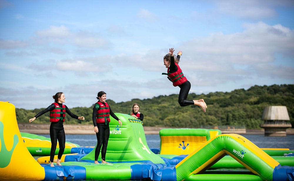 4 teenagers having fun on the wibit inflatable course at bewl water