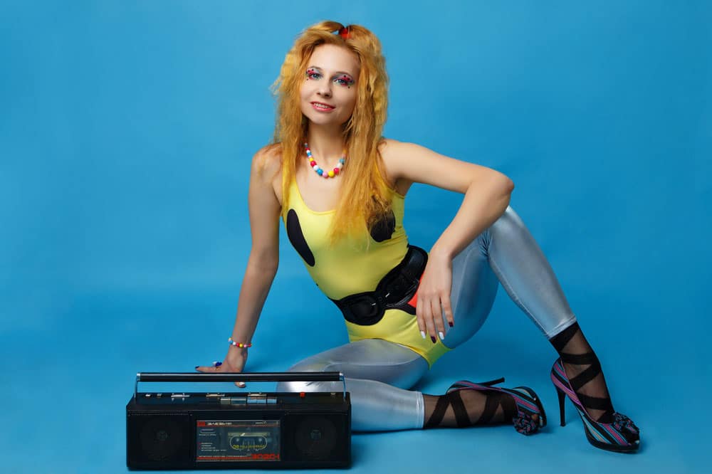 Woman dressed with 80s themed clothing and a cassette player