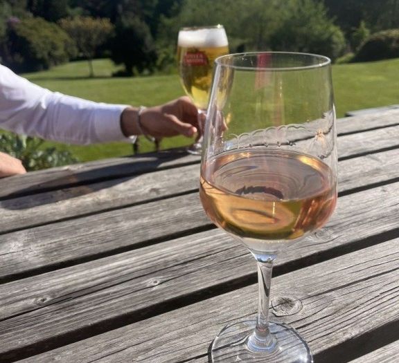Having a glass of wine on a pub bench