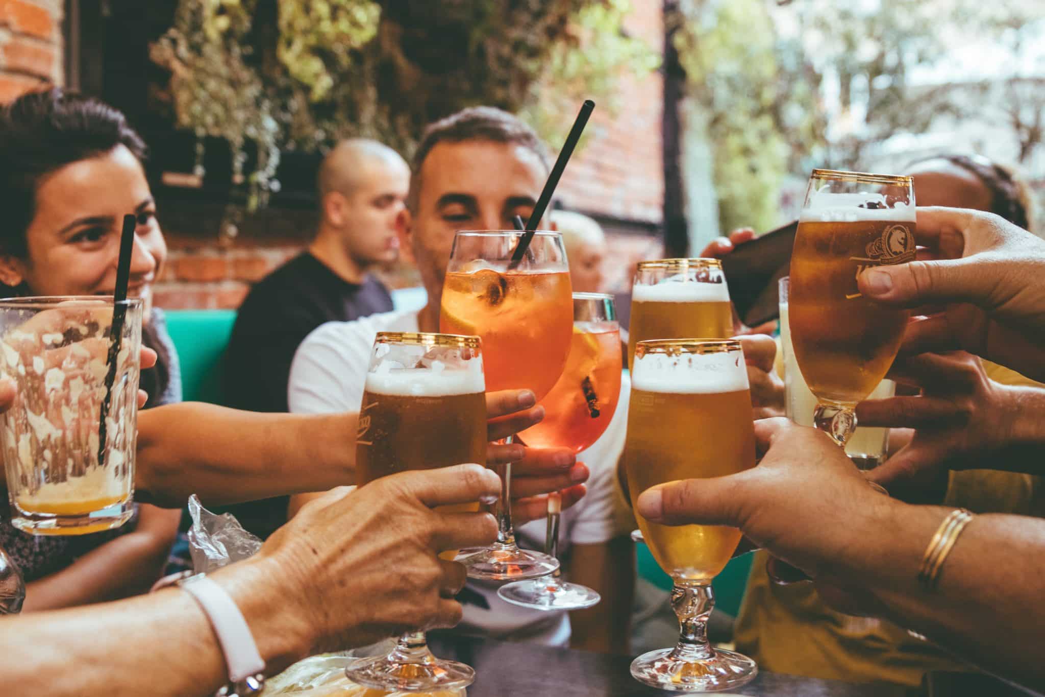 People making a toast with cocktails and beer