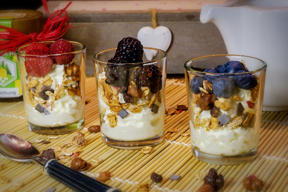 three cups of Yogurt with cereal and fruit