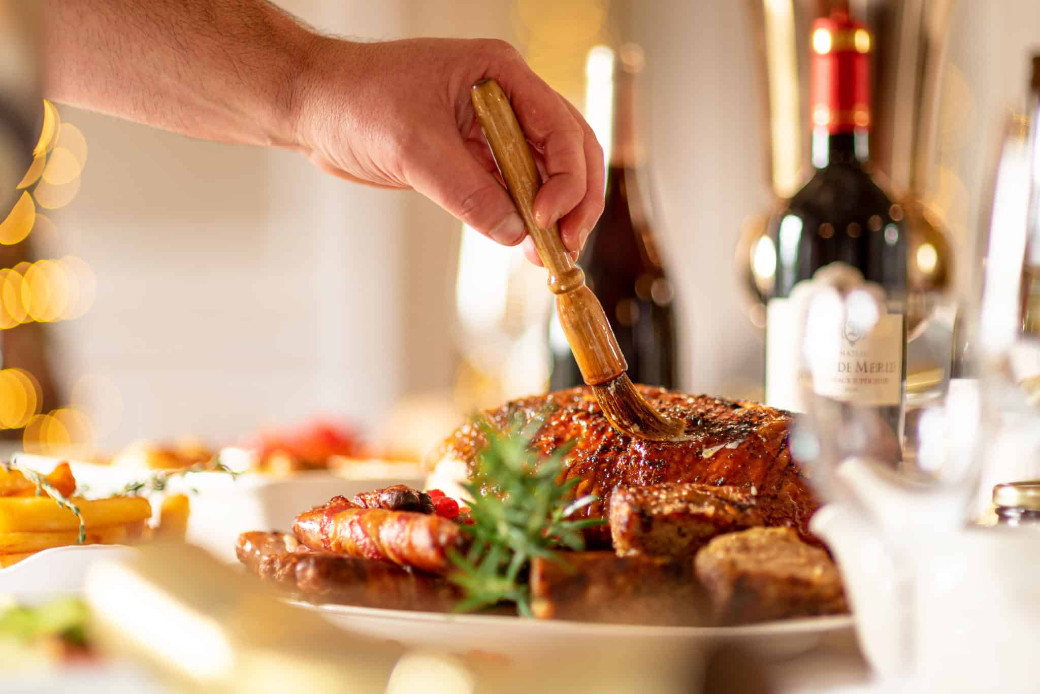 Hand brushing cooked meat dish