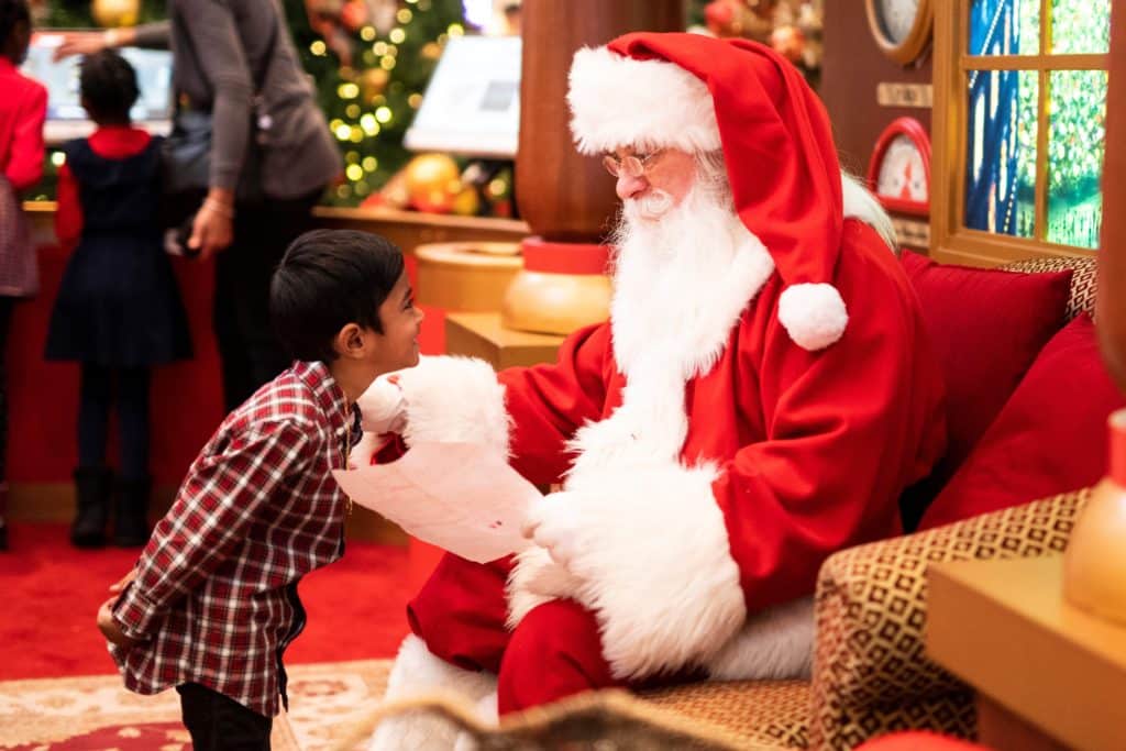 Santa Claus looking at a kids Christmas list