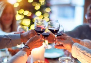 People making a toast with glasses of red wine