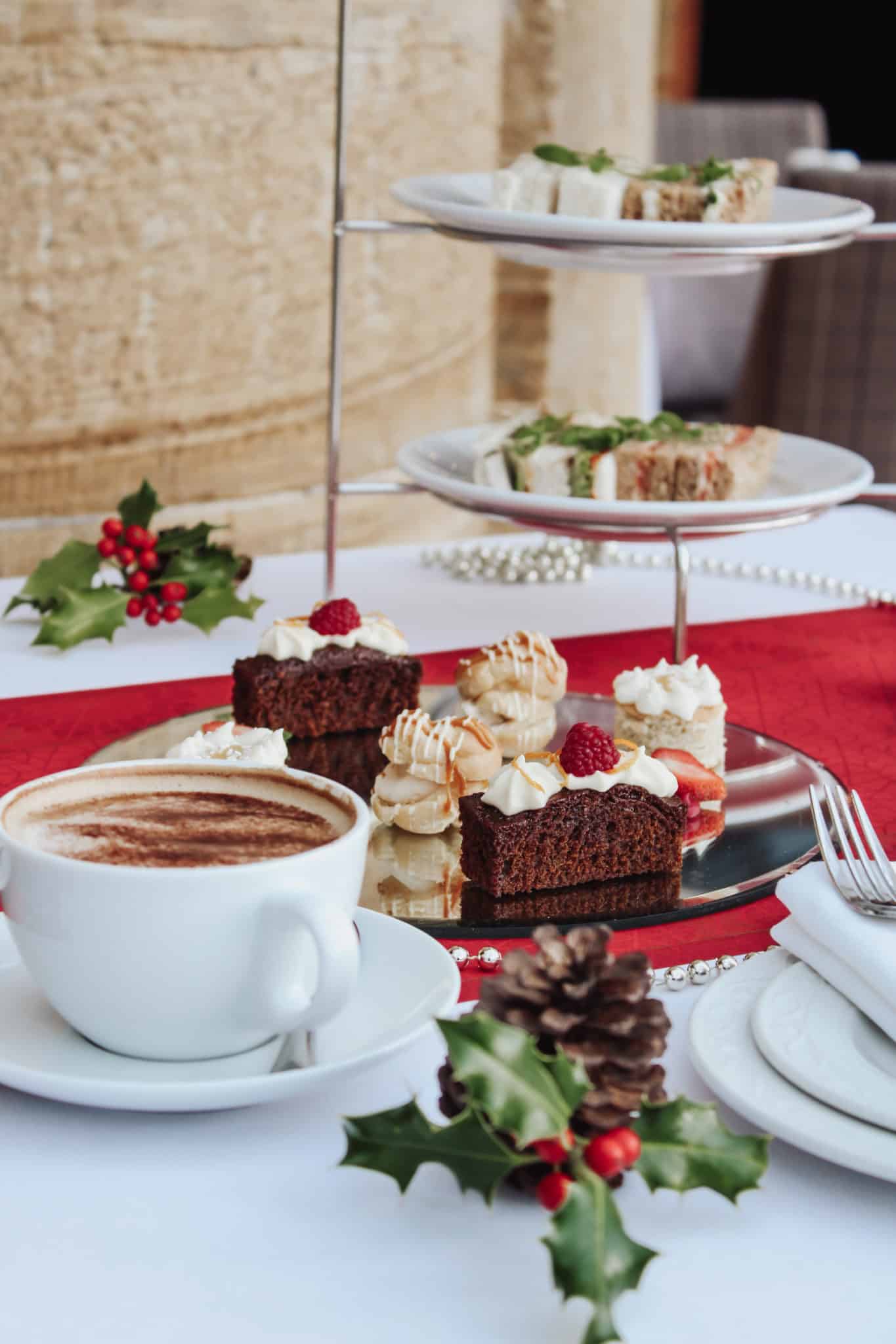 Christmas themed table with pastries, sandwiches and coffee