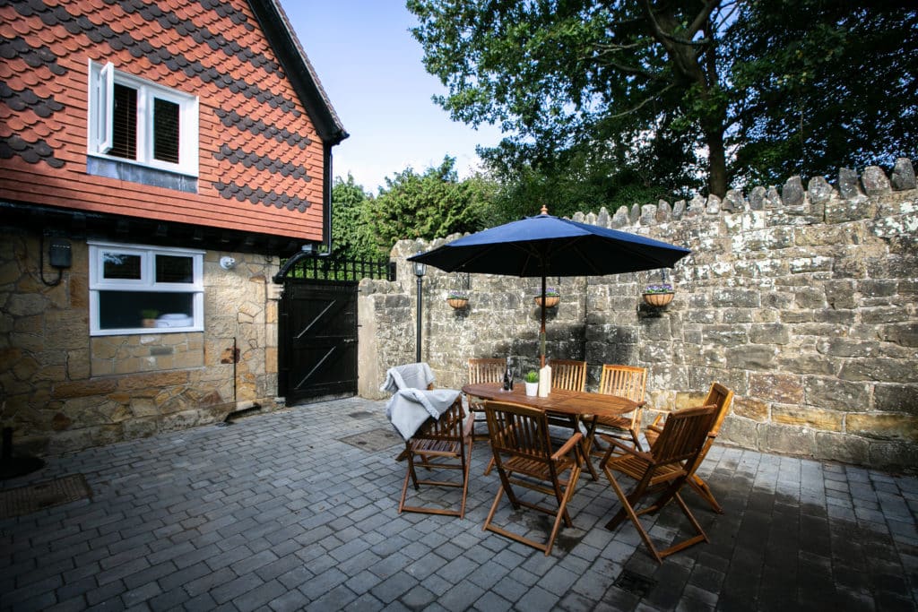 Outdoor area of a cottage with chairs and table