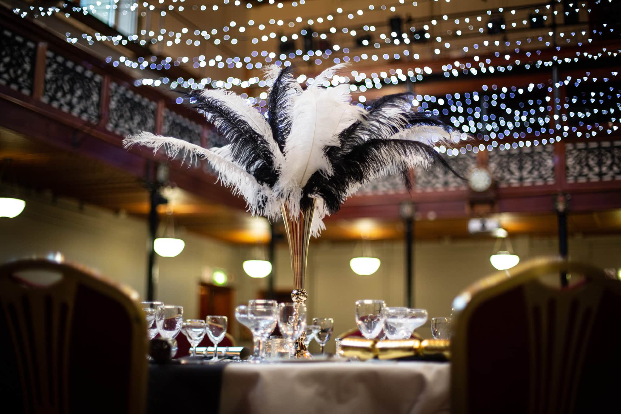 Table with large black and white feathers in the middle