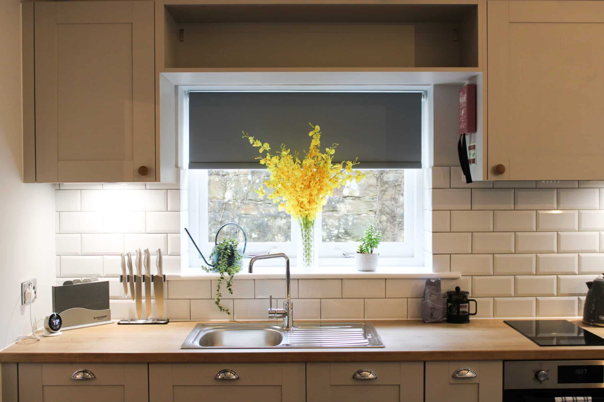 newly installed kitchen in The Garden Cottages with a vase of yellow flowers