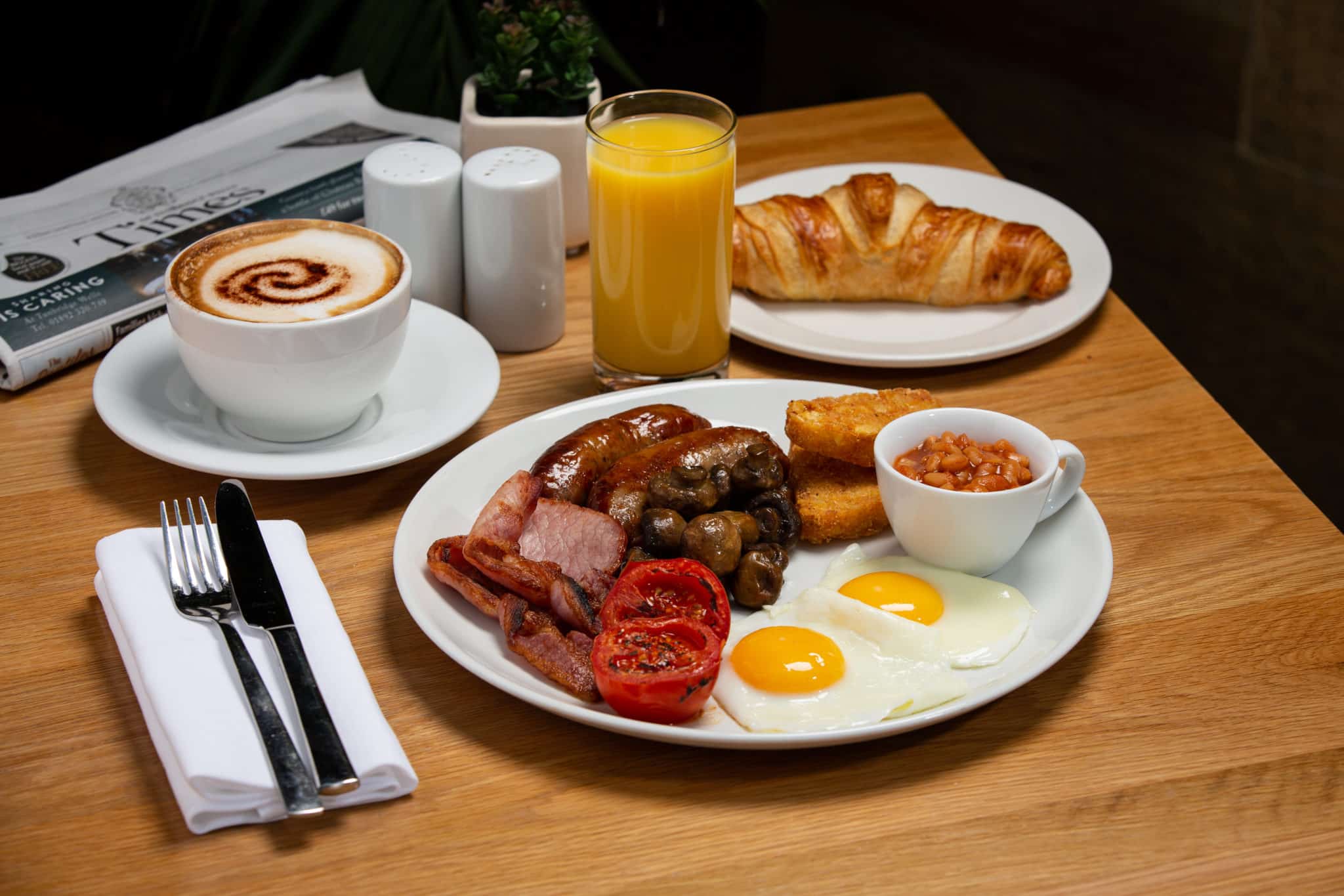 Croissant, English Breakfast, Cappuccino, a glass of orange juice and a copy of the Times newspaper