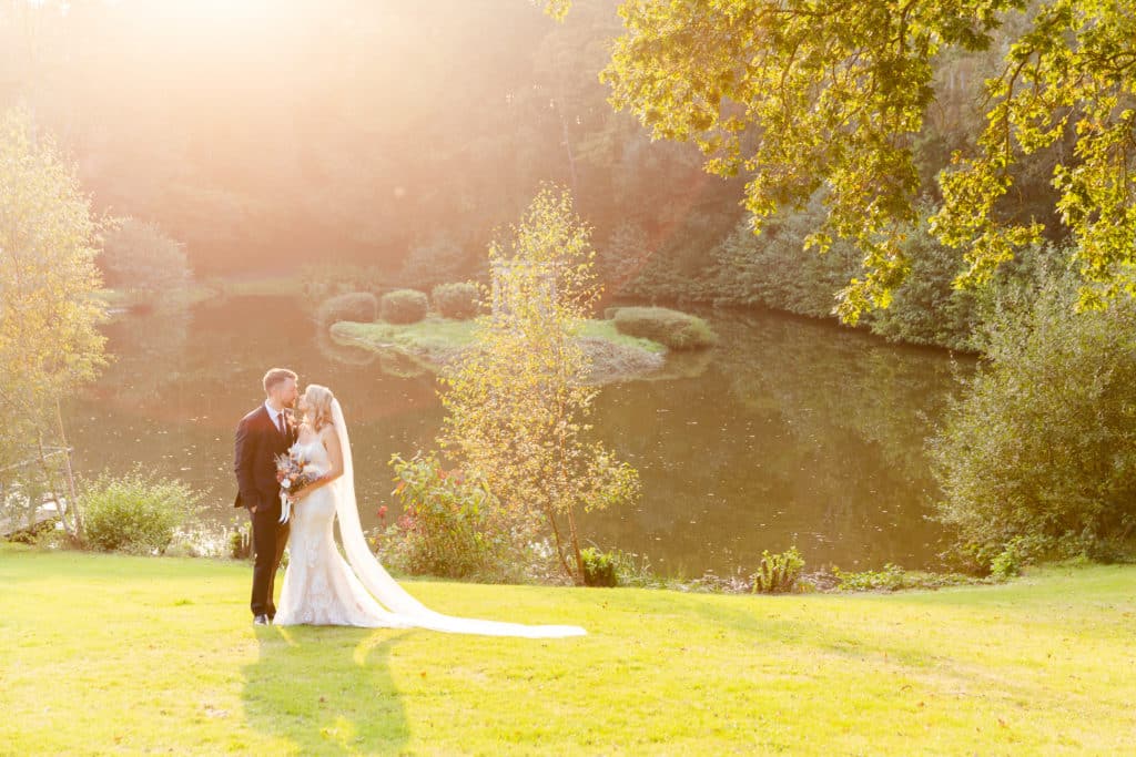 Recently Married Couple standing in front of a lake