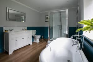 Bathroom with a bathtub, shower, toilet and cabinet with a double sink