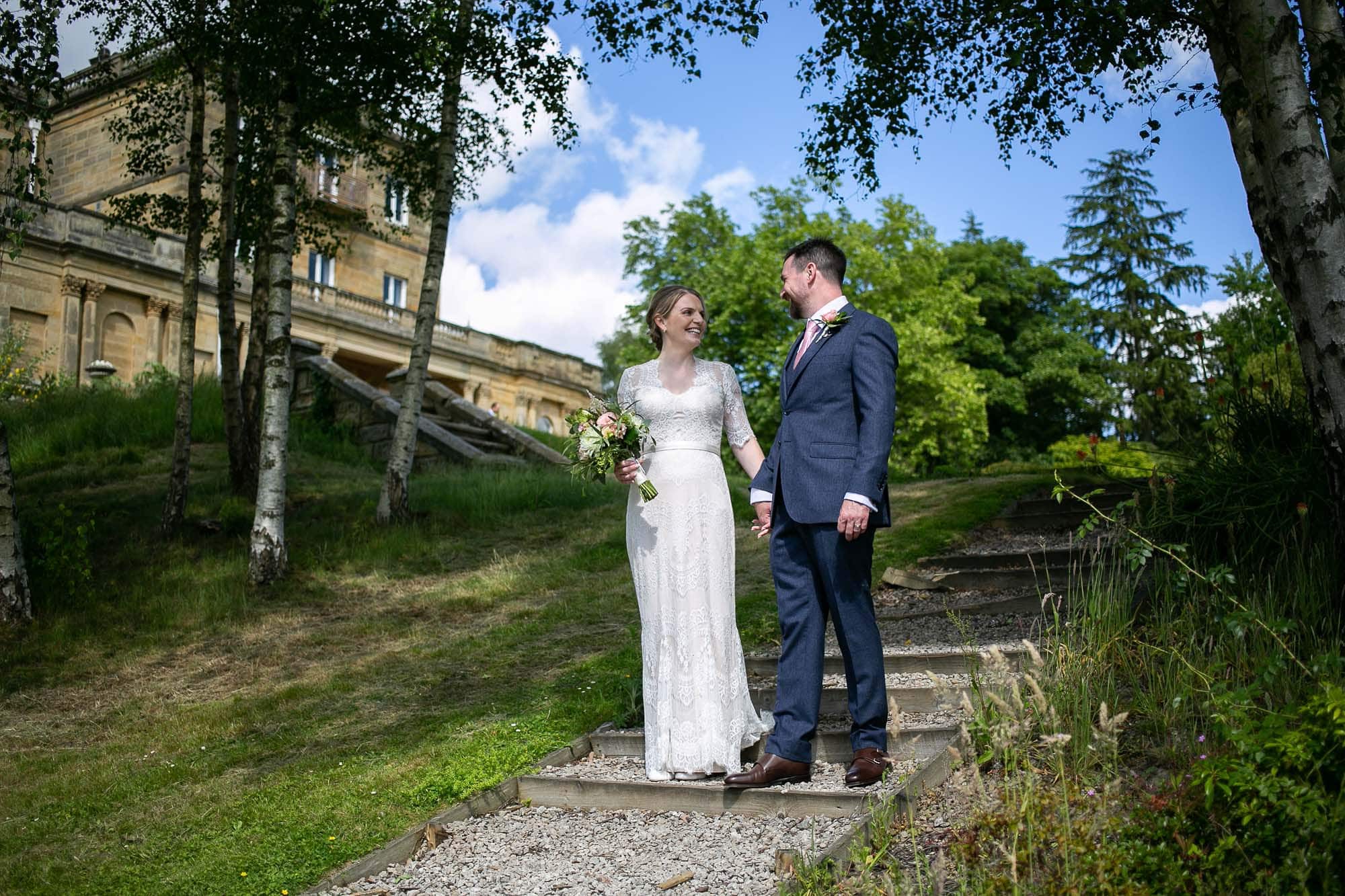 Newly Weds Christy and Oli walking down a path outside salomons estate