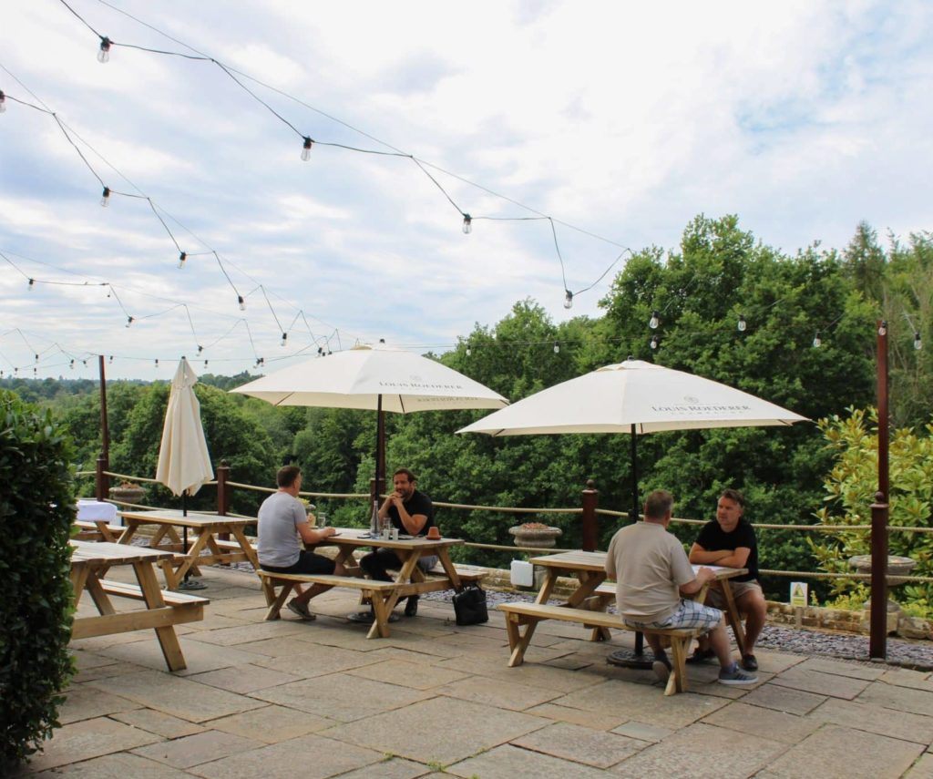 People drinking and talking in an outdoor seating area