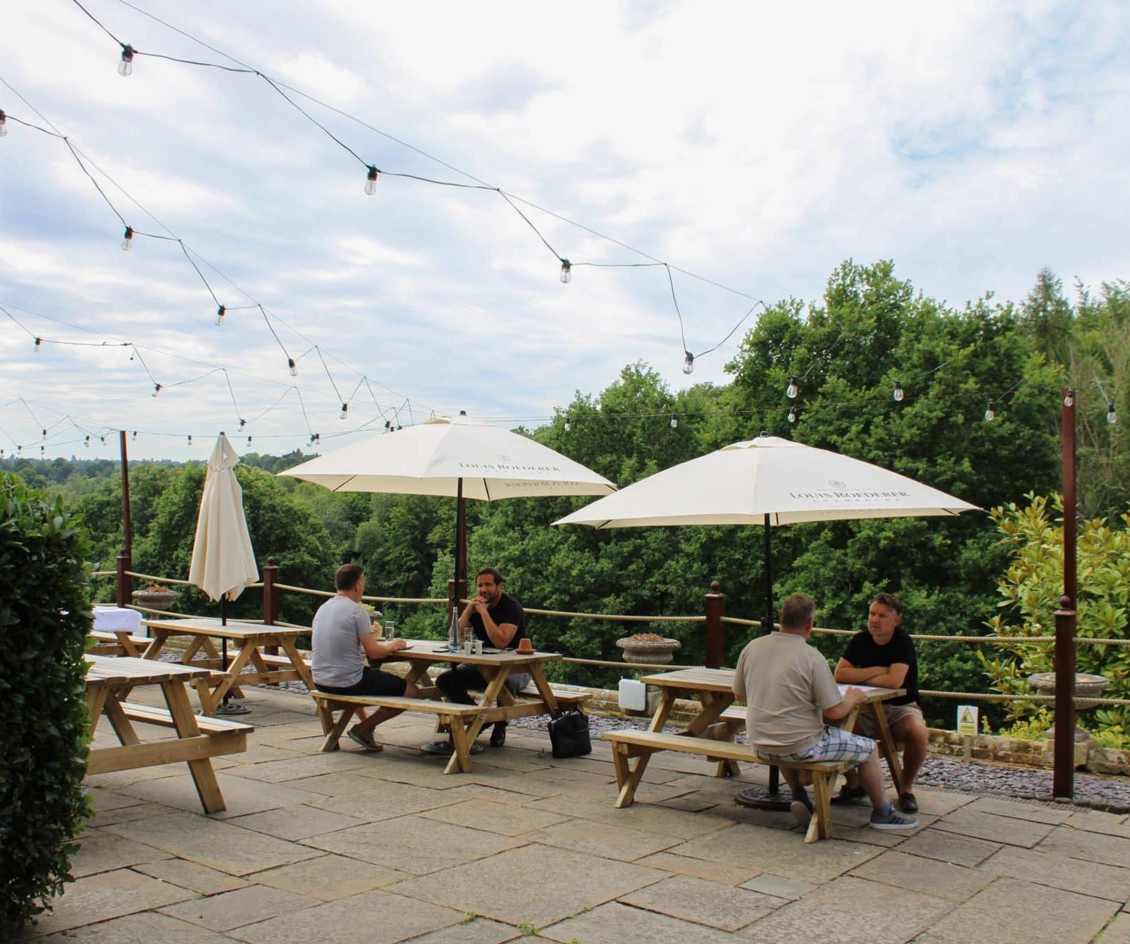 People drinking and talking in an outdoor seating area