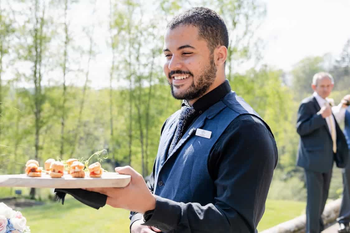 Food and Drink Supervisor holding a plate with snacks