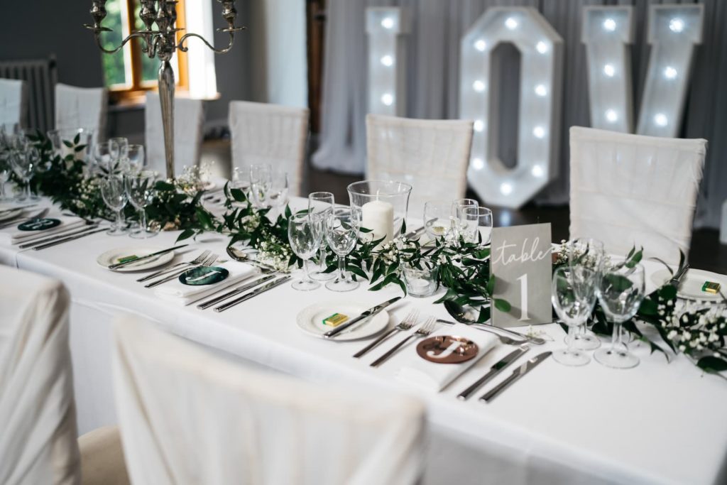Table set with wine glasses and white decoration