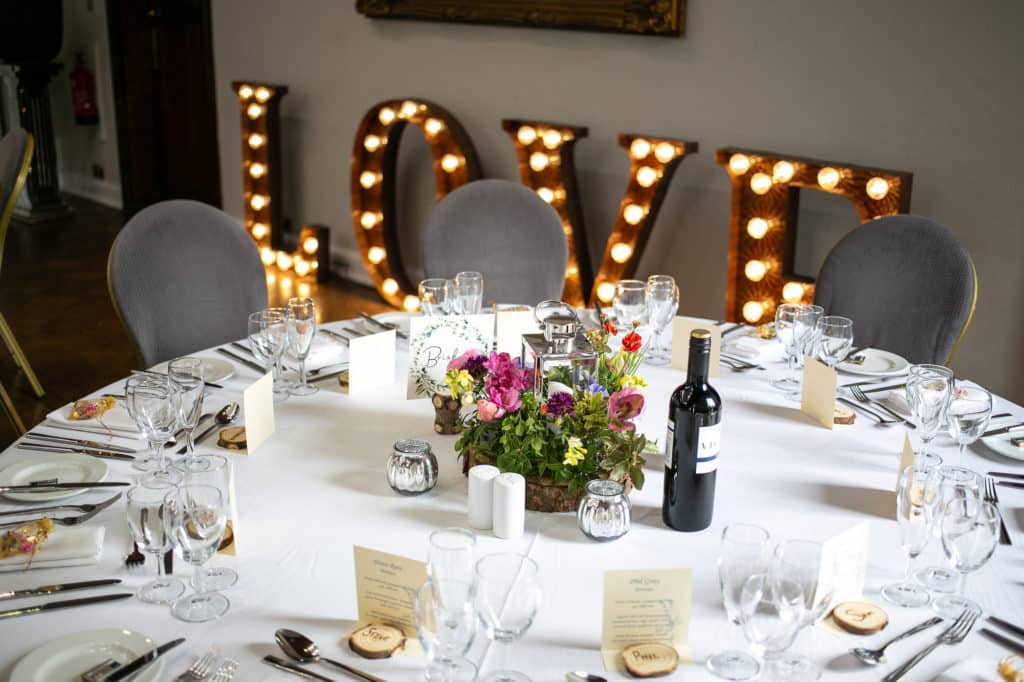 Table with flower arrangement and the word love in the background