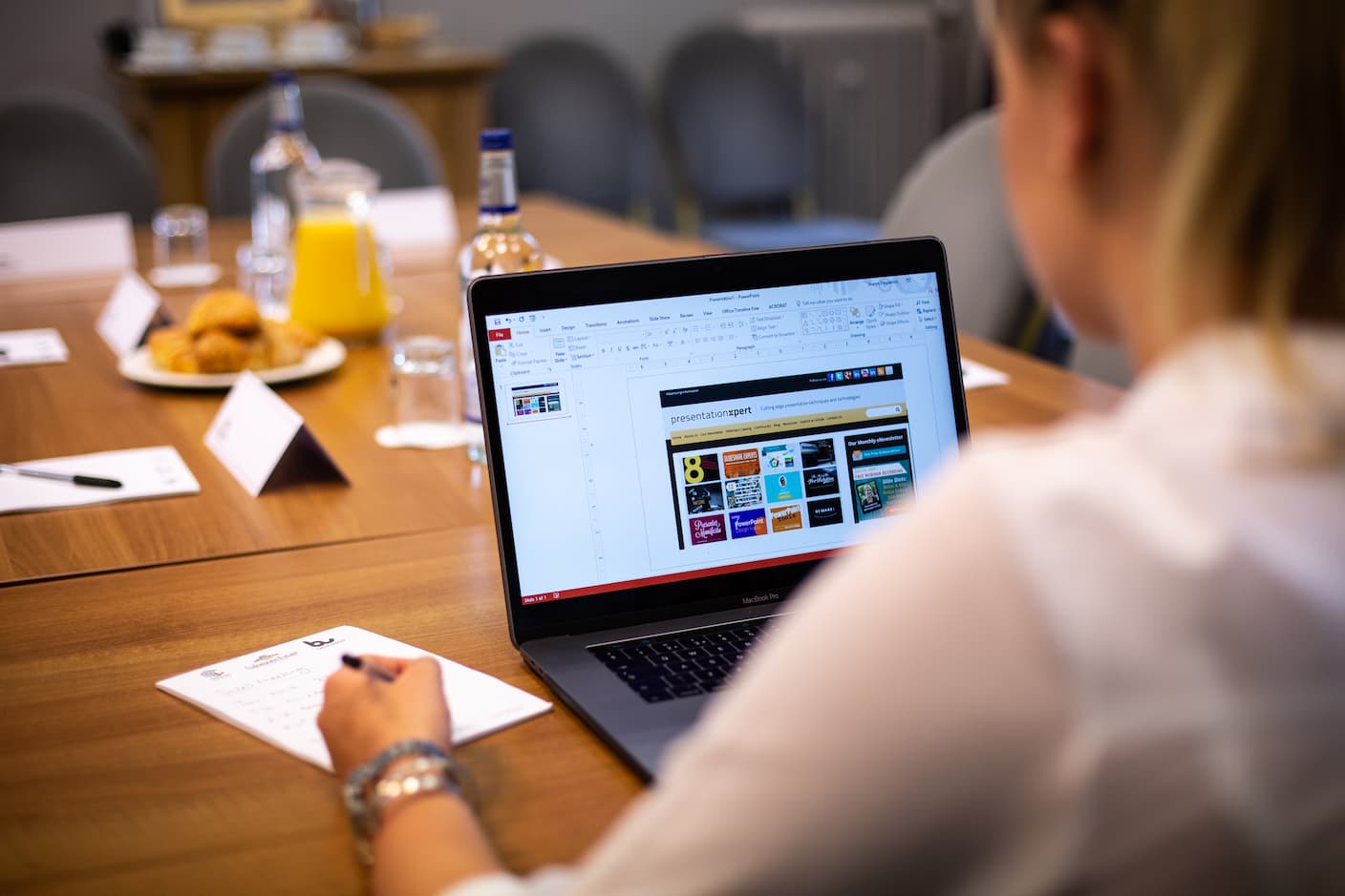 Person working on a PowerPoint presentation at a meeting room