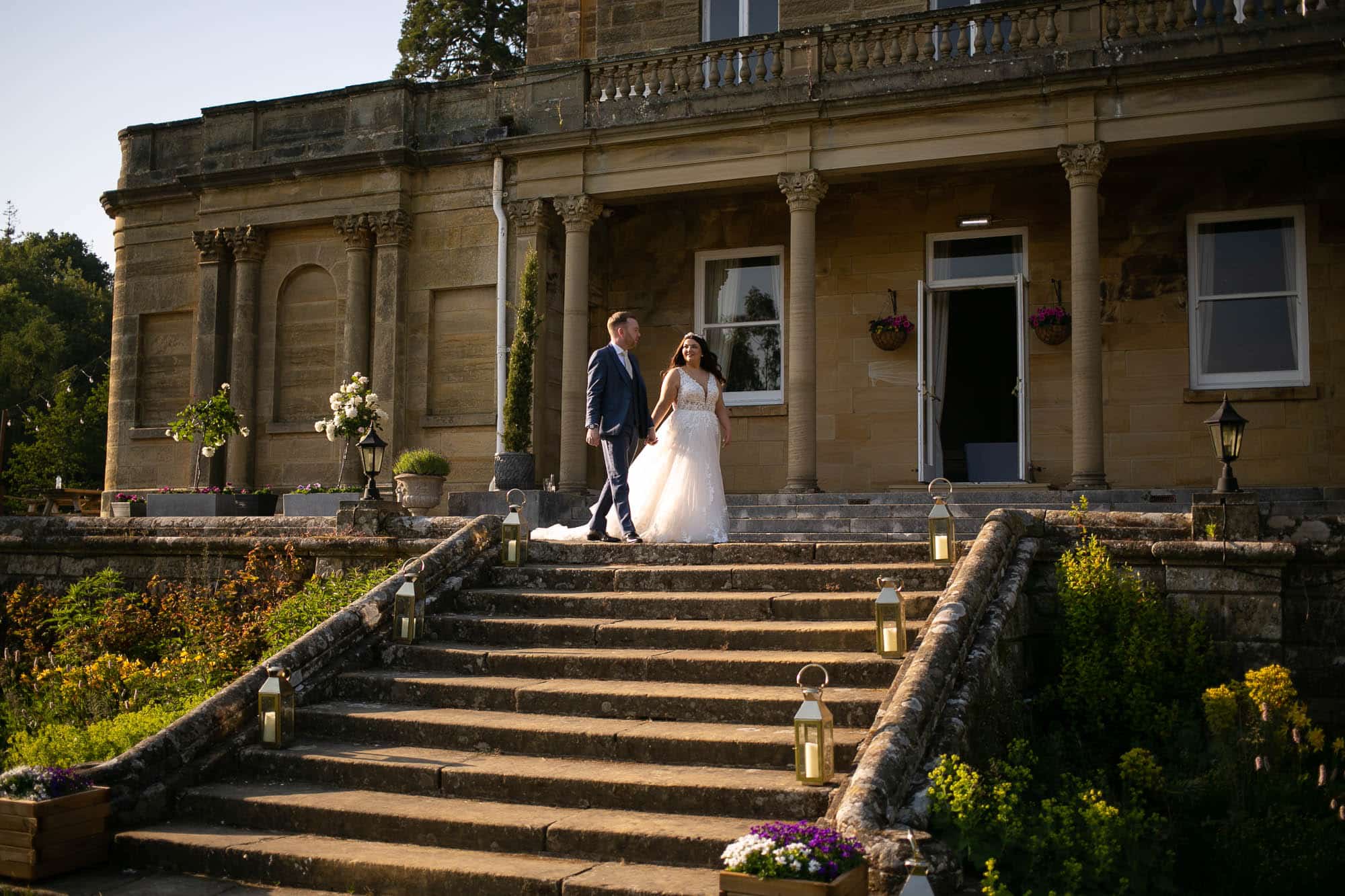 bride and groom walking across the terrace at sunset