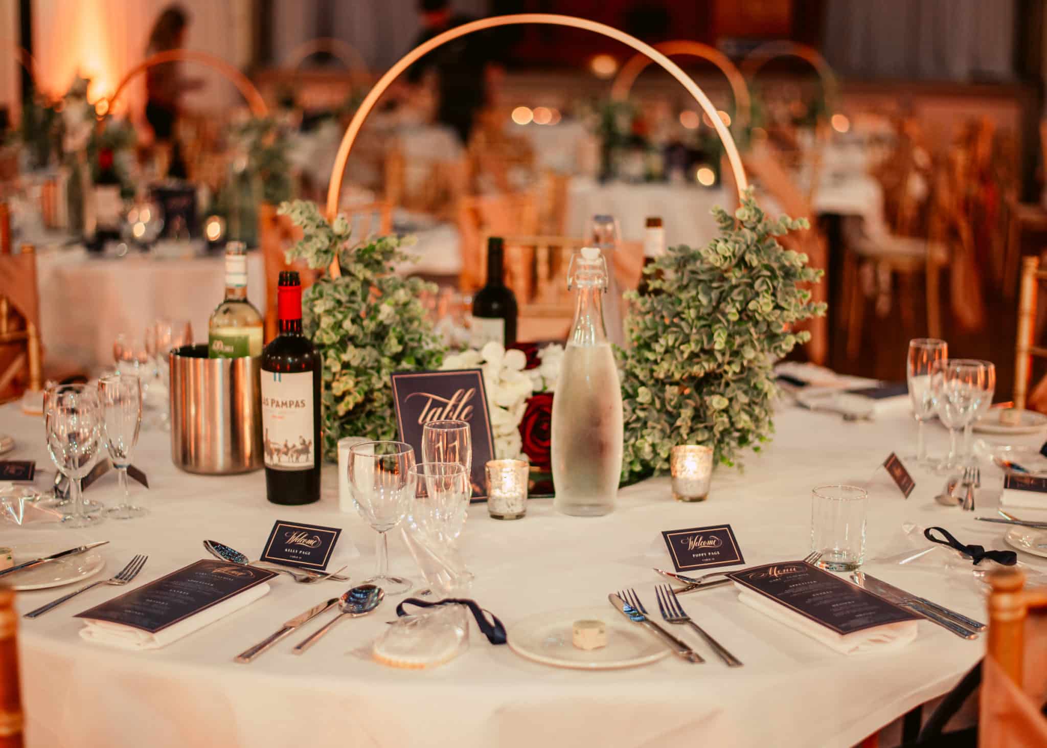 dining table dressed with wedding flowers, wine and wine glasses